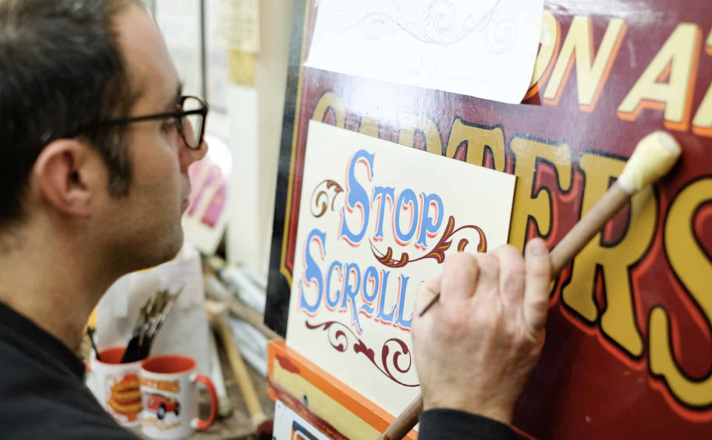Joby hand-lettering a sign