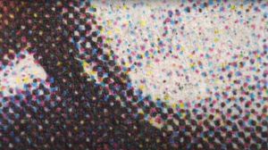 CMYK halftone dots viewed under a hyper-macro lens.